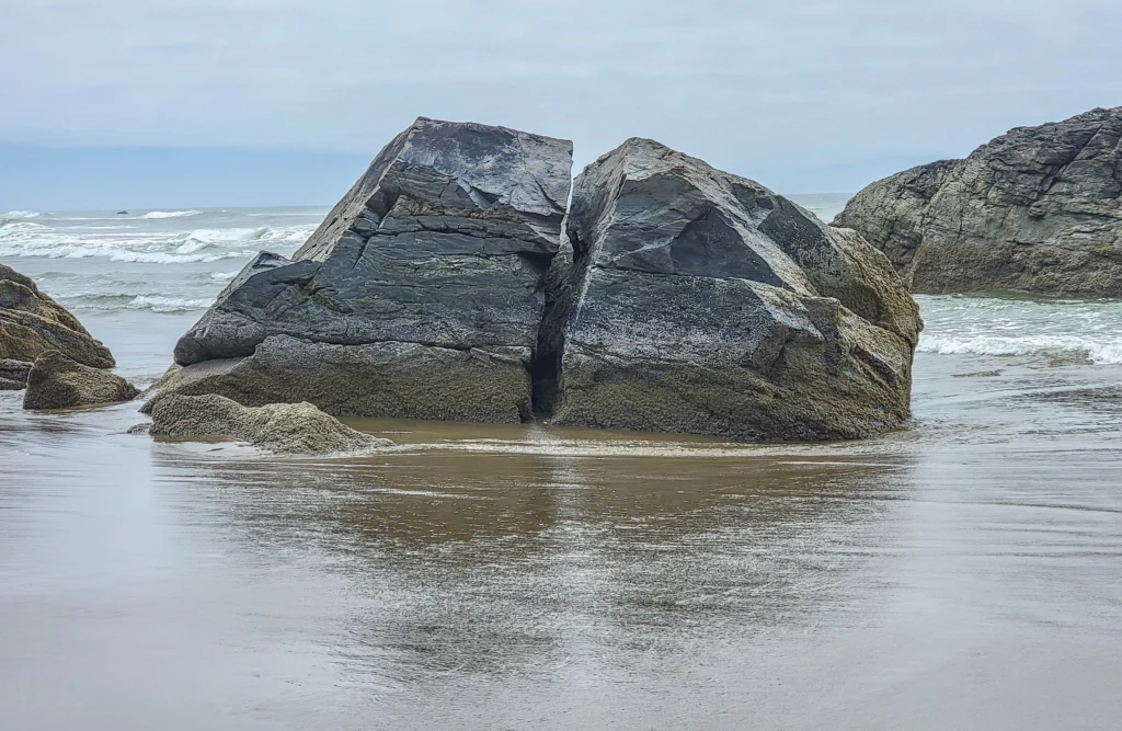 Split rock at the waterline showing fractured layers, Bandon Beach