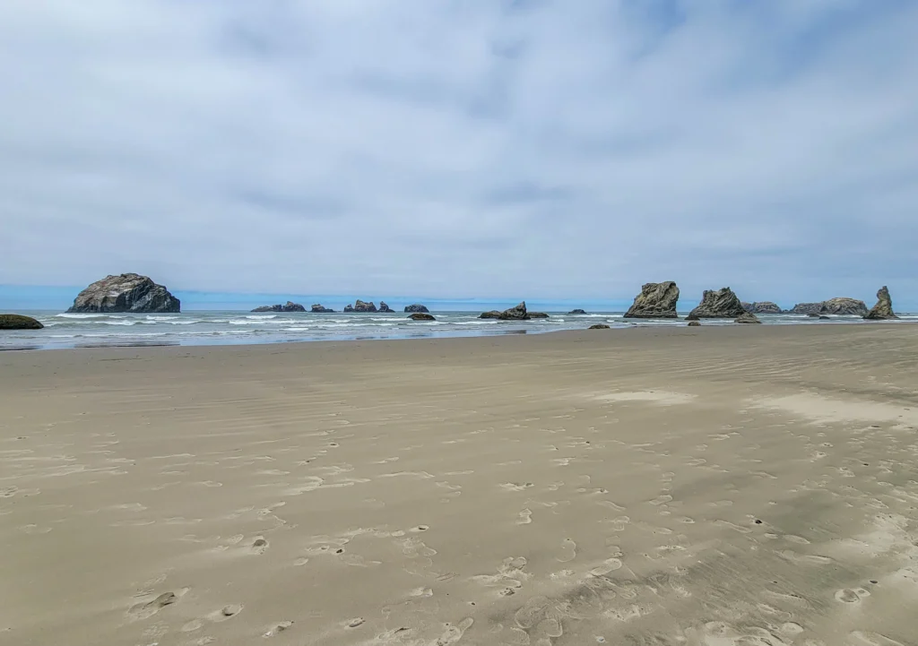 Face Rock at left with the Cat and Kittens beside it and Wizard's Hat at far right, Bandon Beach, Oregon
