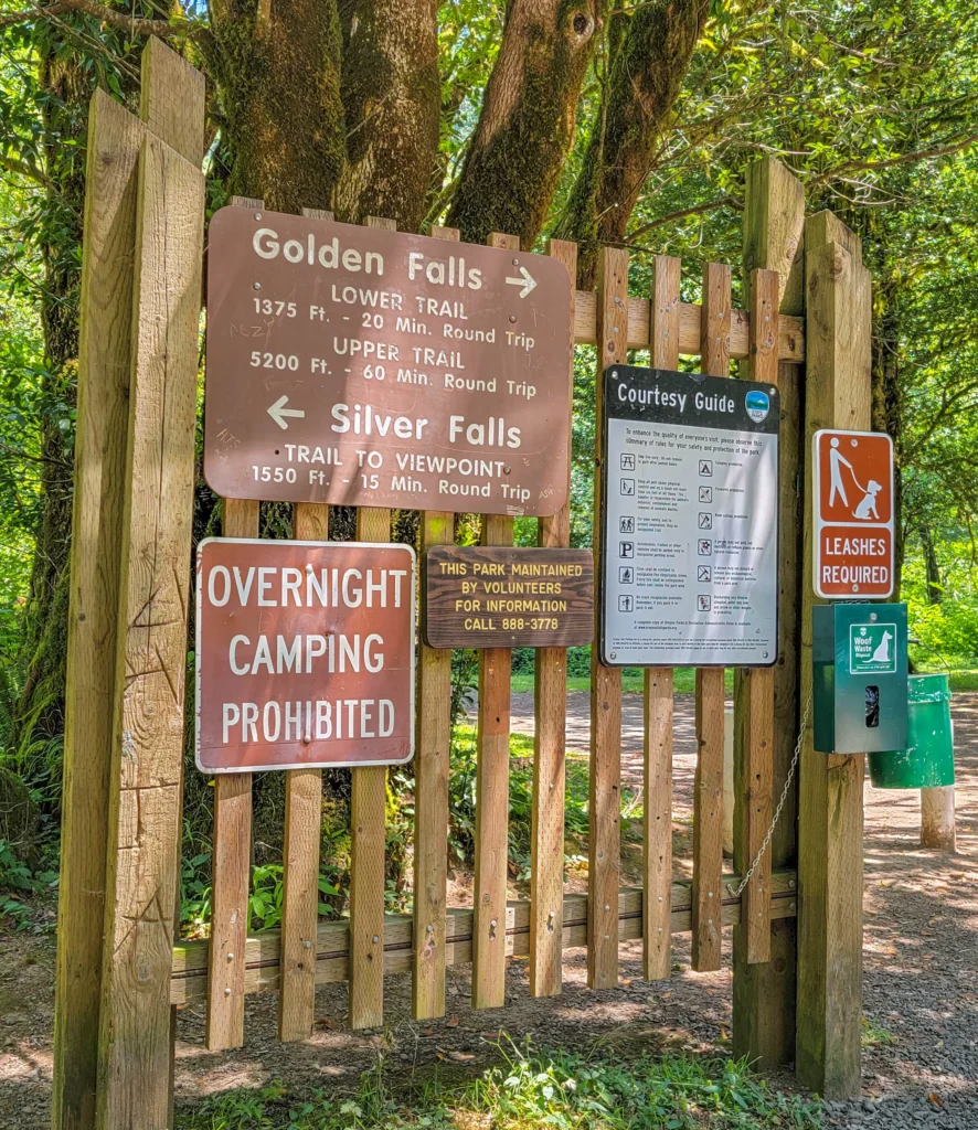 Trailhead sign at Golden and Silver Falls listing trail distances in feet