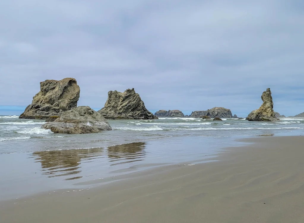Wizard's Hat sea stack at right among a cluster of rocks, Bandon Beach, Oregon