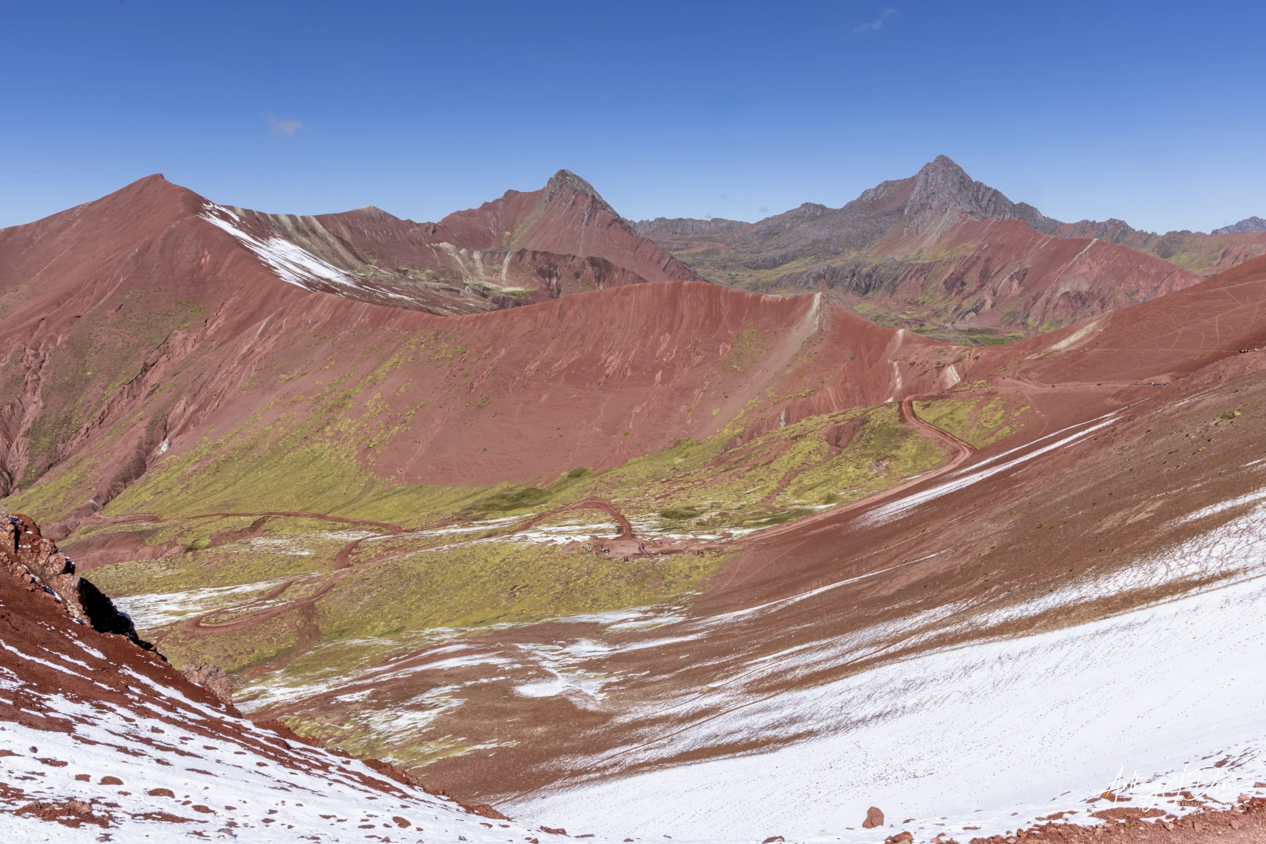 Red Valley view Panoramic view of Red Valley beneath a clear blue sky with patches of snow and a winding dirt trail.